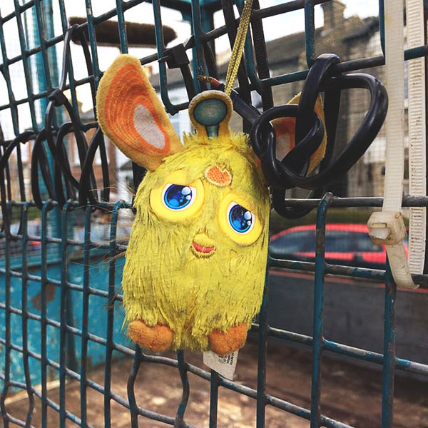 Abandoned, unwanted, unloved, cuddly toy, yellow thing tied to a bin cart